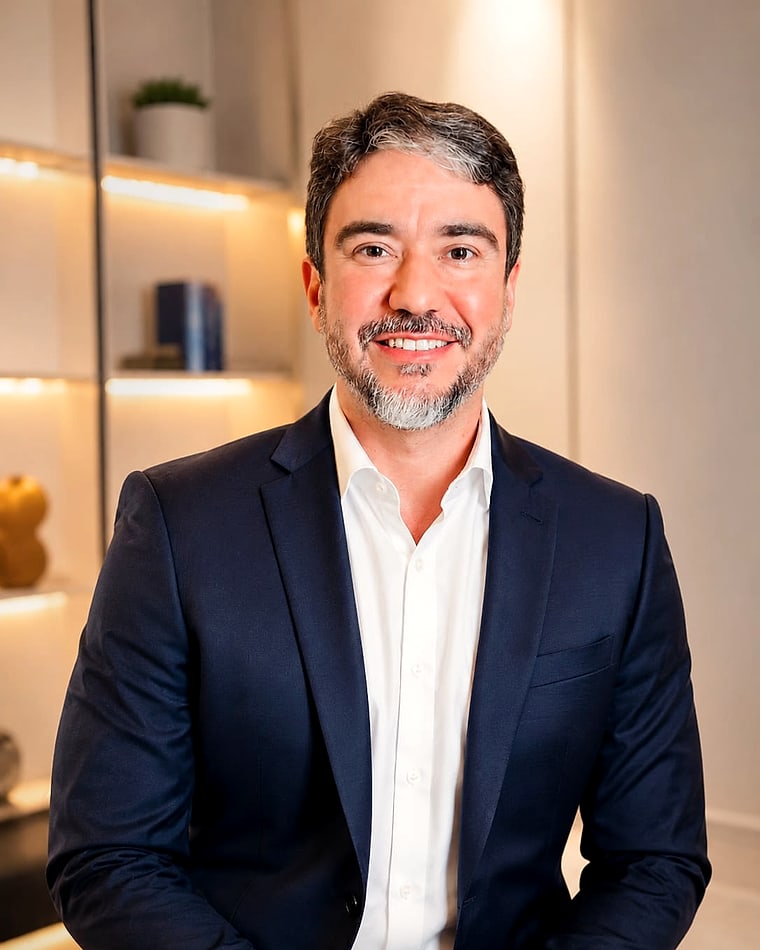 Dr. Thales Lamartine, oftalmologista, de terno azul-marinho e camisa branca, sorrindo na recepção da clínica em Belém